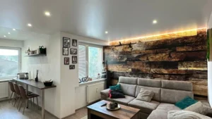 Biely napínaný strop v obývačke s bodovým osvetlením a LED podsvietením v modernej domácnosti